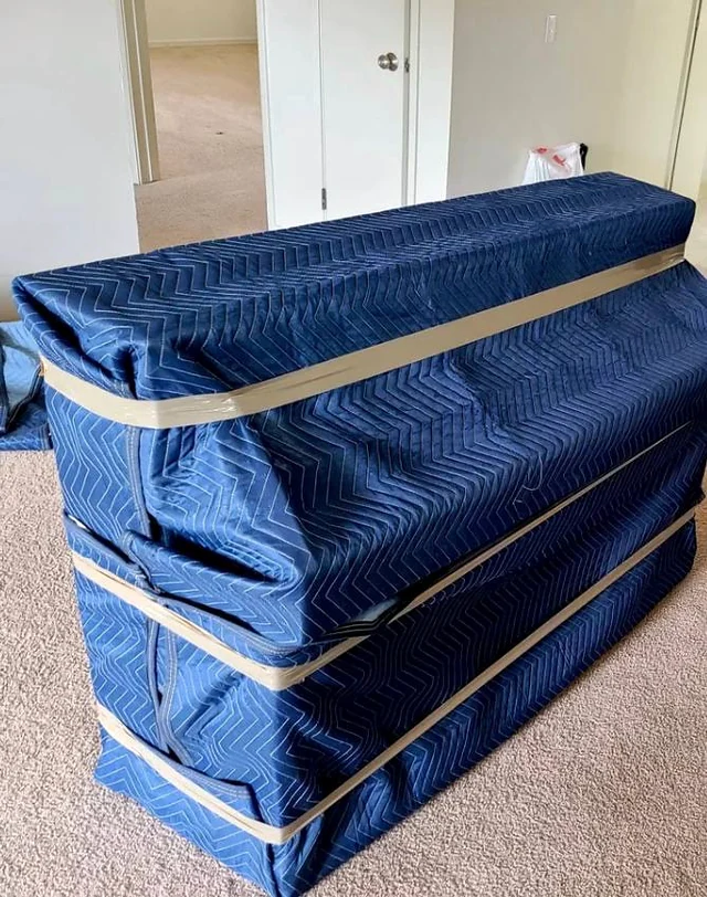 Furniture covered with blue moving blankets